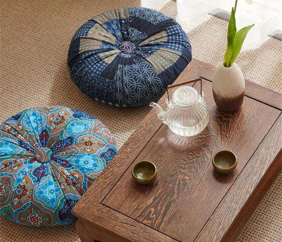 Handmade Boho round thick floor cushions in vibrant colors near a wooden table with tea set, enhancing cozy home decor.