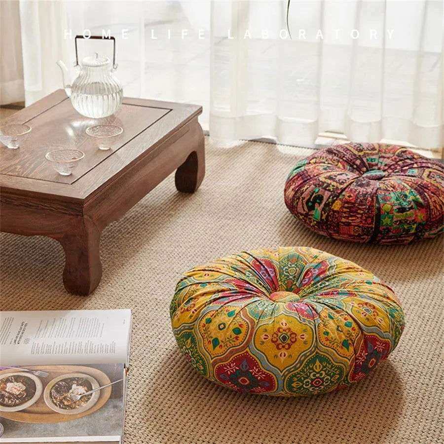 Handmade Boho Round Thick Floor Cushion in vibrant colors, featuring a unique center button design, placed on a cozy rug beside a wooden table and decor.