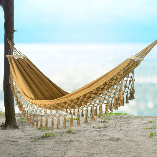 Macramé double hammock with wood bars in camel color, featuring intricate detailing and tassels for outdoor luxury and style.