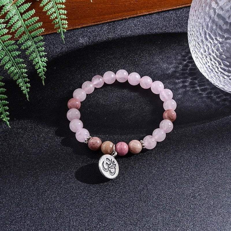 Rose Quartz Rhodonite Mala bracelet with OM charm and pink tassel, featuring heart-healing energy stones.