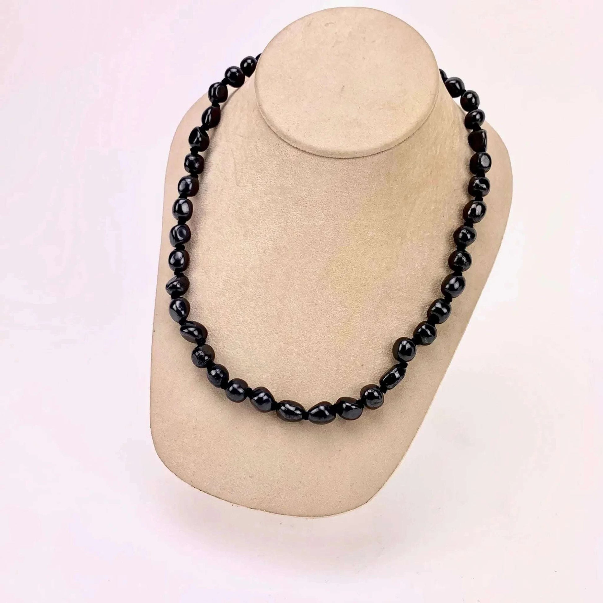 Shungite tumbled bead necklace with 18-inch length and 7-10 mm stones, displayed on a mannequin.